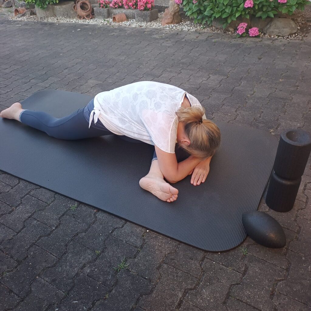Melanie ruht in der Kindhaltung auf der Matte — ein Moment zum Nachspüren.
